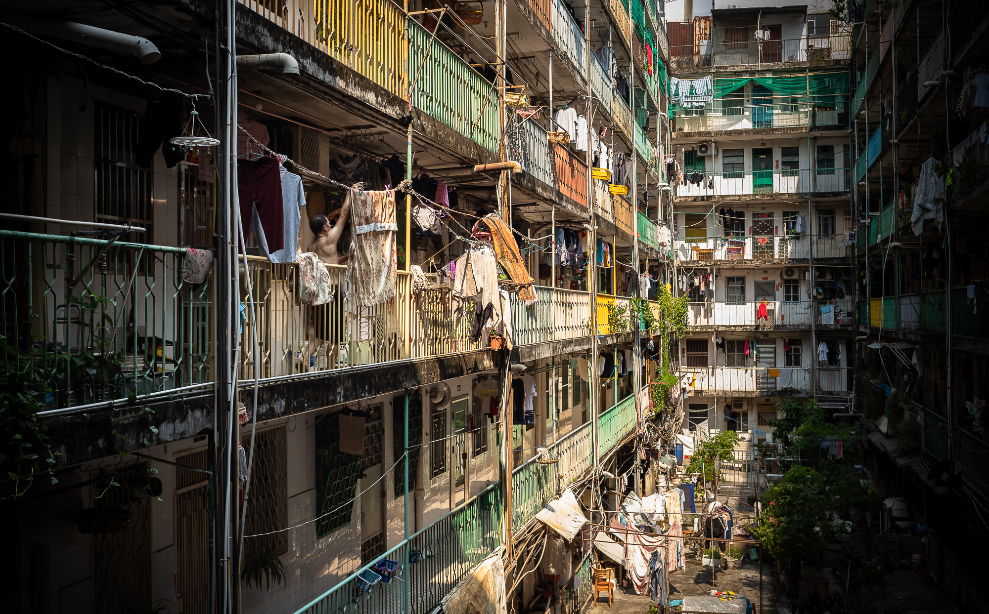 A resident hangs up his laundry at a block of flats in Areia Preta, where many migrant workers live